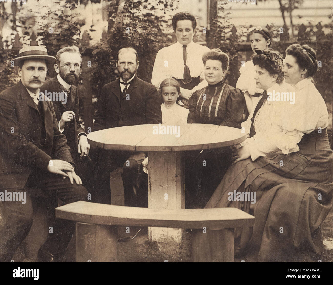 Foto d'epoca. Ritratto di gruppo della famiglia a tavola rotonda in un giardino, Russia 1904 Foto Stock