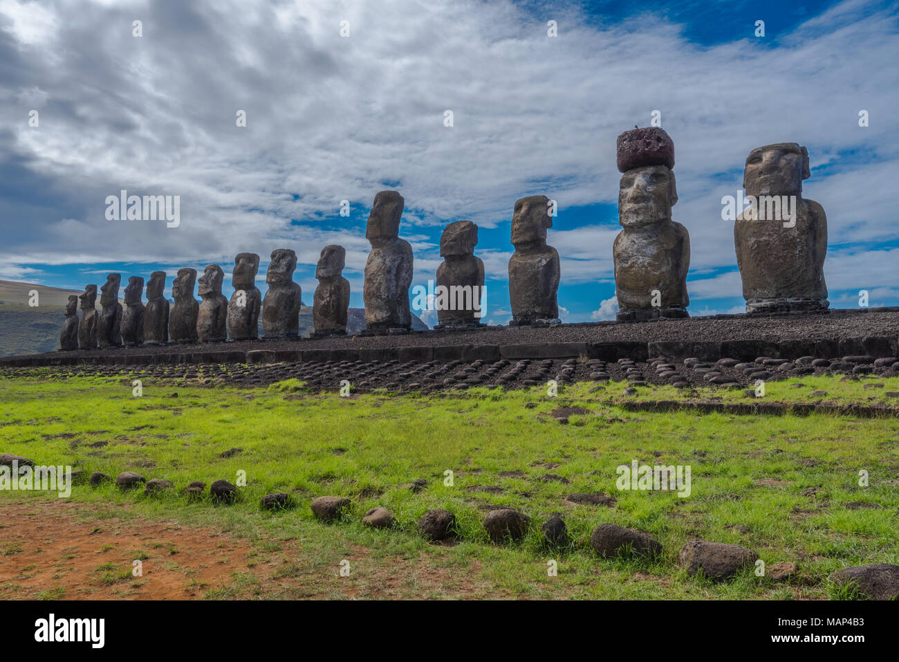 Ampia angolazione di 15 statue Moai rivolti verso l'interno sopra l'isola di pasqua a Tongariki con una drammatica nuvola bianca e blu sullo sfondo del cielo. Foto Stock
