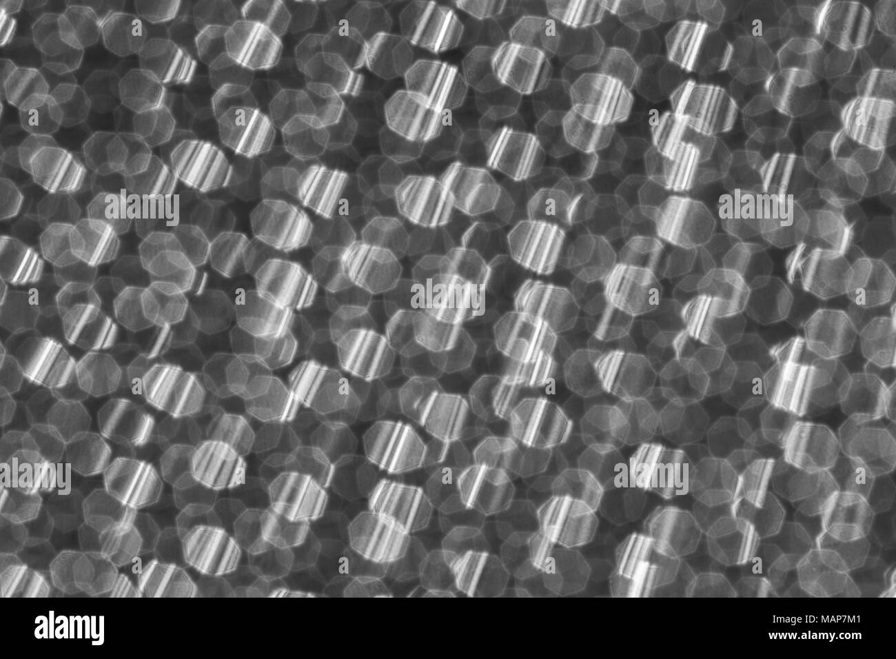 Soft-focus abstract in bianco e nero di micro-foto di perforazioni nel foglio metallico di un Braun rasoio elettrico. Metafora possibili connessioni astratta. Foto Stock