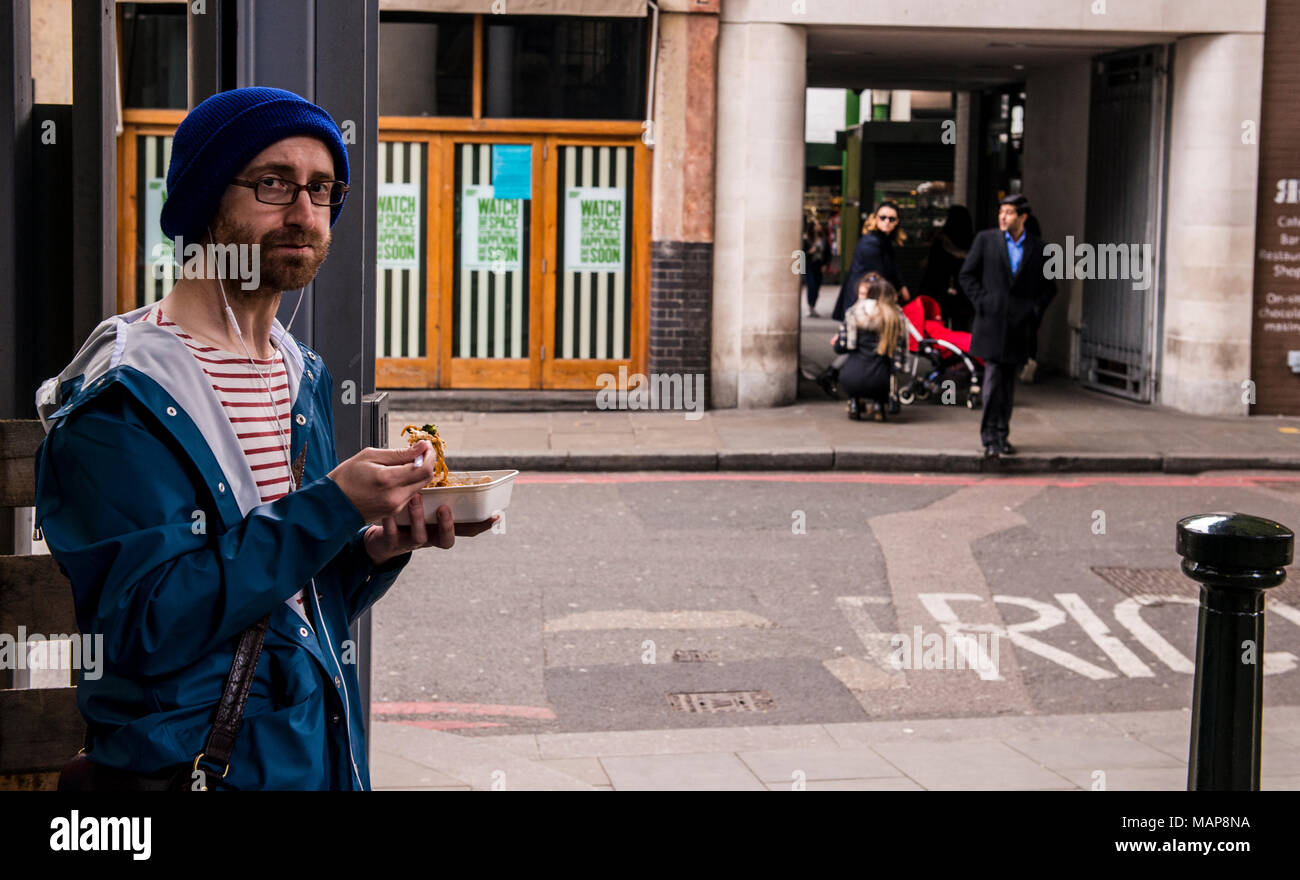 Uomo di mangiare cibo da asporto vicino al Mercato di Borough, Southwark, Londra, Inghilterra, Regno Unito Foto Stock