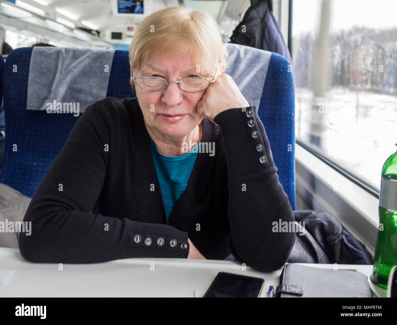 Di mezza età caucasian donna seduta vicino alla finestra del treno Foto Stock