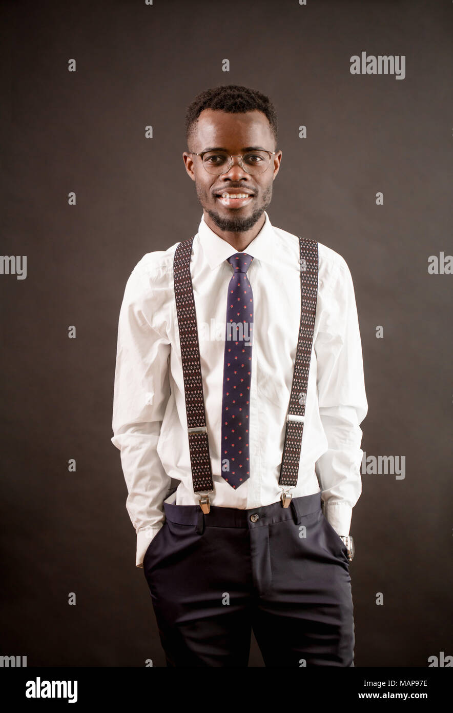 Moda uomo africano con gli occhiali, autoreggenti, camicia bianca,  pantaloni e tirante Foto stock - Alamy