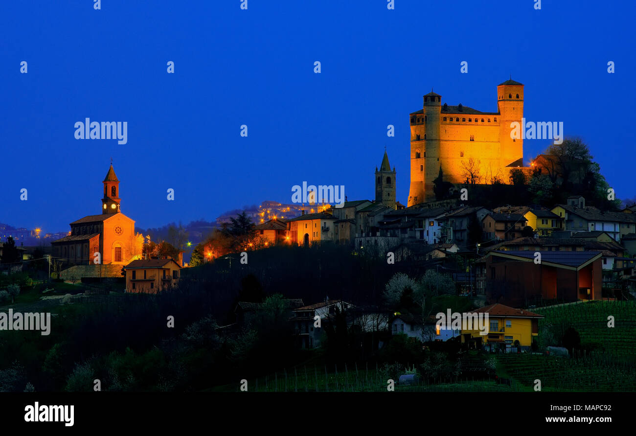 Vista notturna di Serralunga d'Alba. In background, oltre 15 km di distanza, è possibile vedere il villaggio di Murazzano con la sua alta torre di avvistamento medievale. Foto Stock