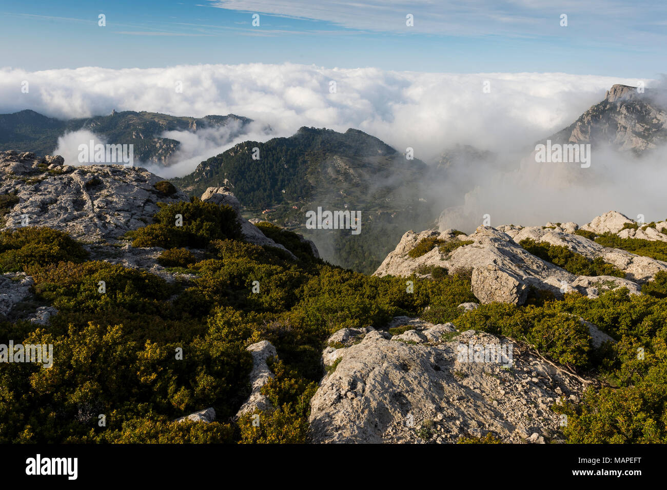 Rocky andscape presso i Puertos de Beceite (porte de Beceit) con nuvole sopra le montagne e le rocce con vegetazione in primo piano, Spagna Foto Stock