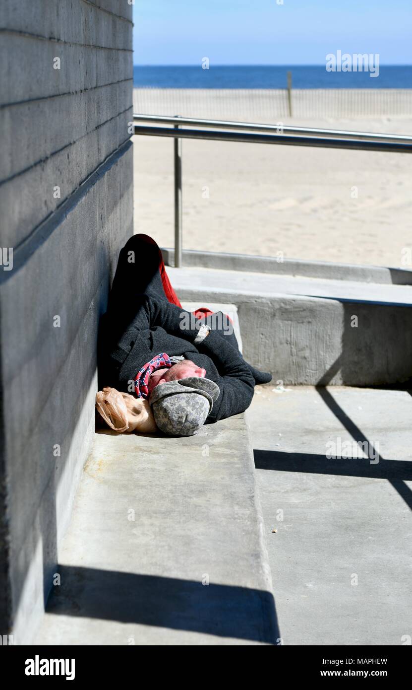 Senzatetto uomo dorme accanto alla spiaggia di Ocean City Maryland, Stati Uniti d'America Foto Stock