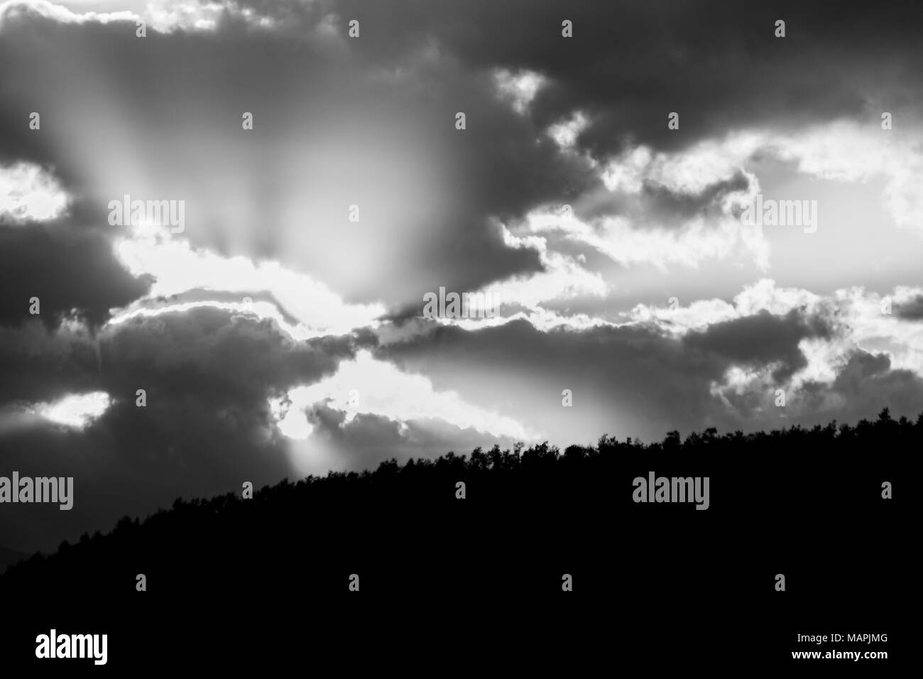 Tramonto su una valle con raggi di sole uscente attraverso alcune nuvole Foto Stock
