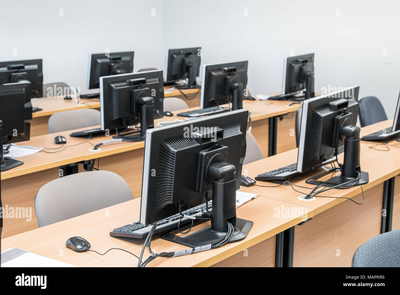 Svuotare la sala computer ordinatamente disposta per gli studenti in un laboratorio informatico. Foto Stock