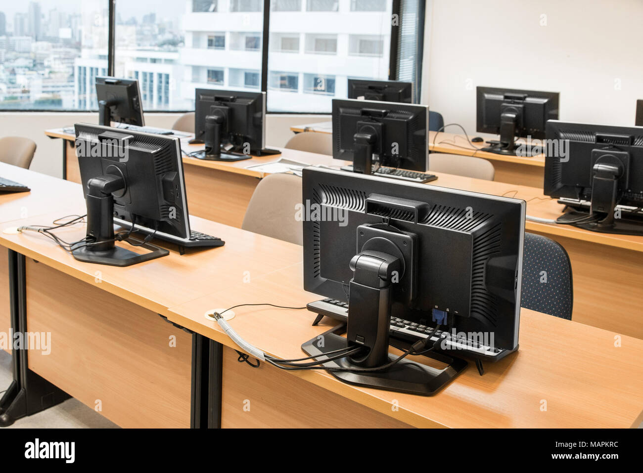 Svuotare la sala computer ordinatamente disposta per gli studenti in un laboratorio informatico. Foto Stock