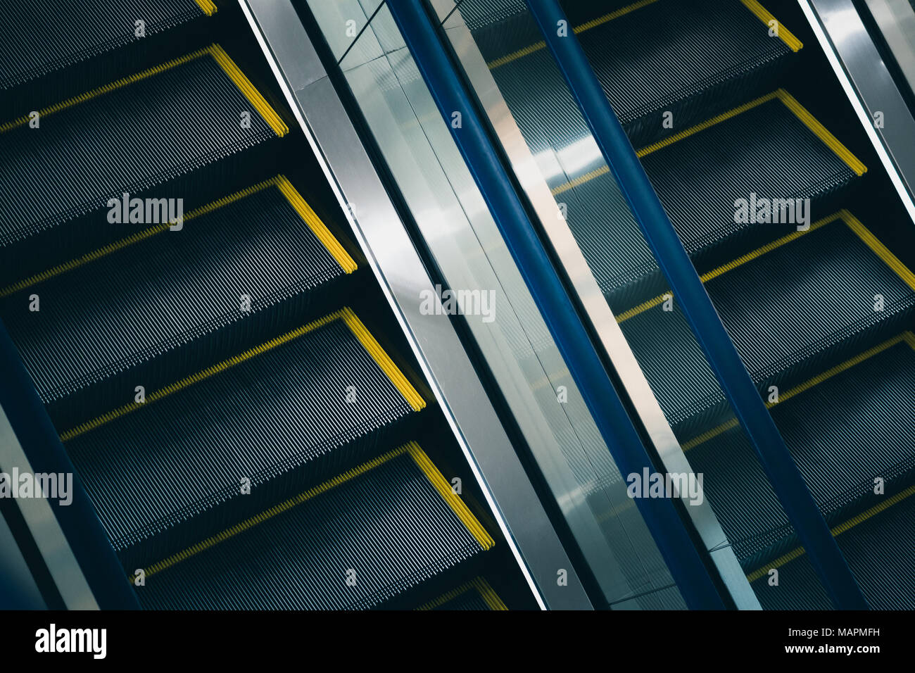 Escalator closeup: due scale di metallo con parapetto in vetro tra di essi Foto Stock