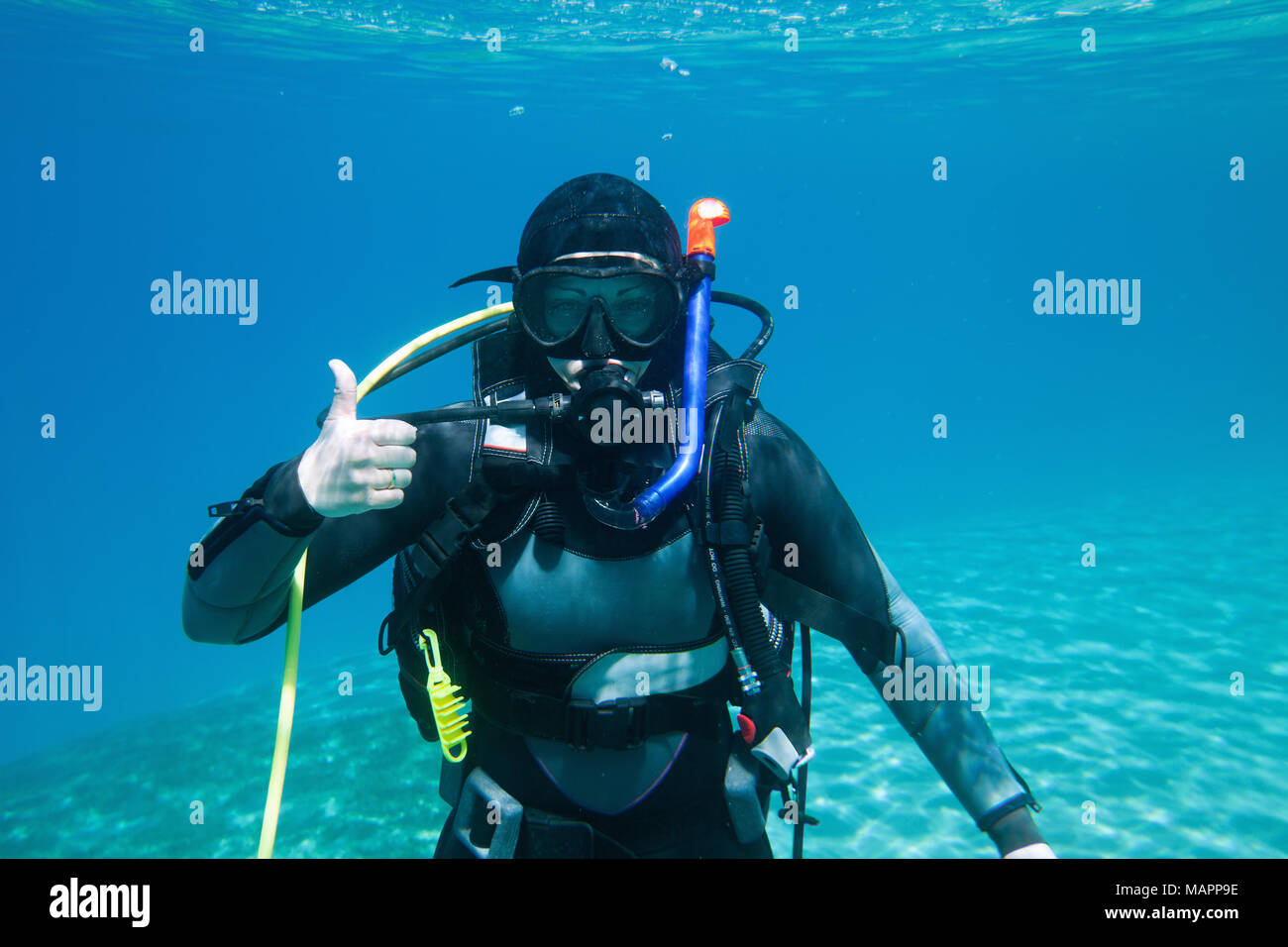 Un ritratto di un subacqueo in un mare che mostra il segno "salita" ('start nello spostamento verso l'alto') Foto Stock