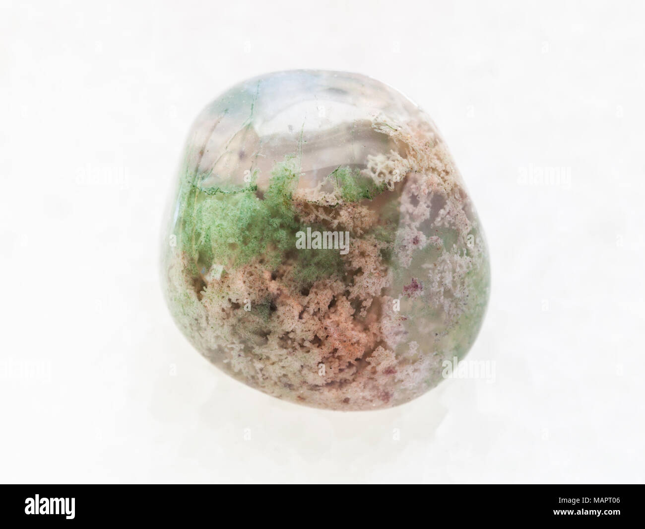 Le riprese in modalità macro di minerale naturale campione di roccia - lucidato Moss gemma agata bianca su sfondo marmo Foto Stock