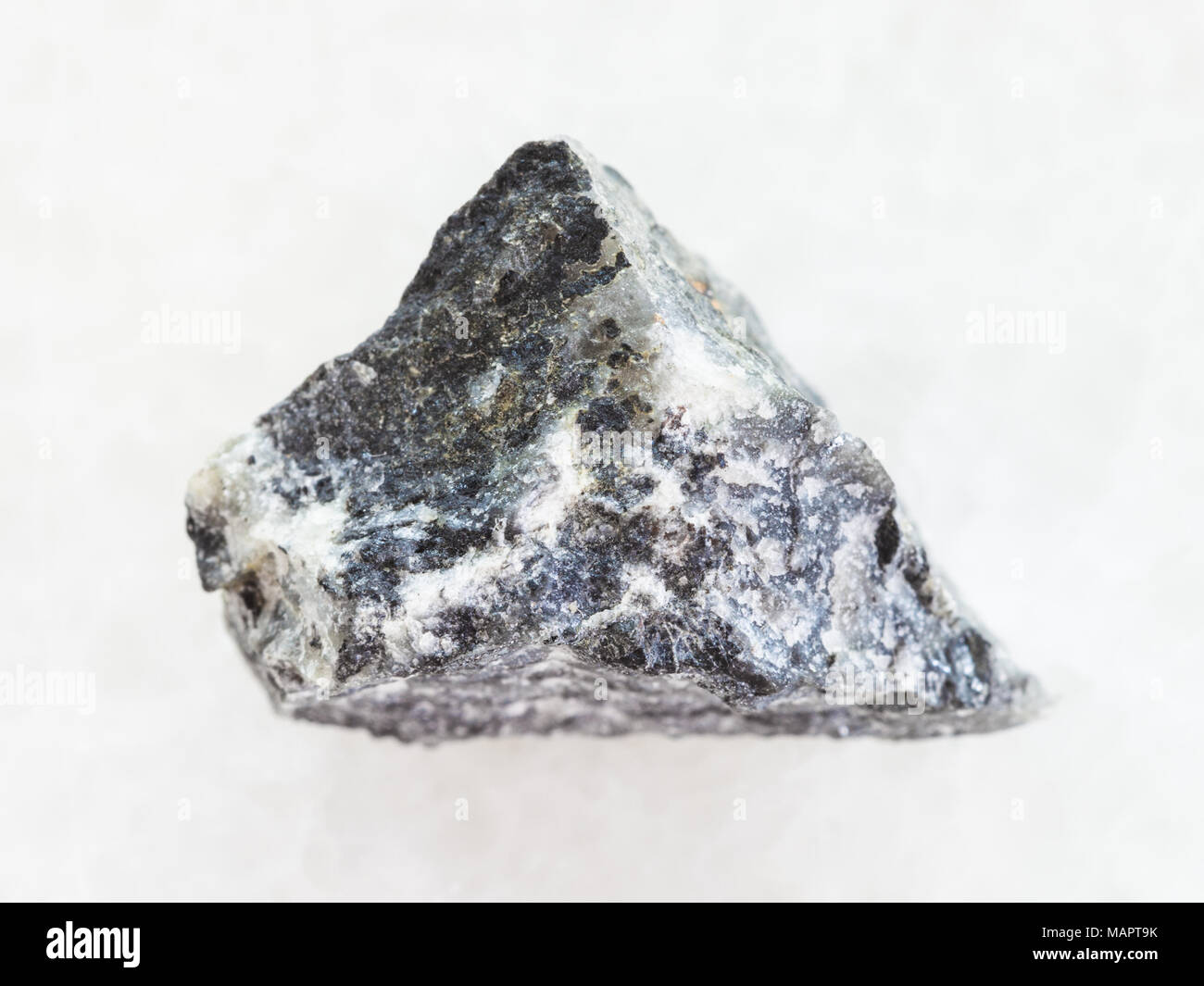 Le riprese in modalità macro di minerale naturale campione di roccia - materie stibnite (antimonite) minerale sul marmo bianco sullo sfondo Foto Stock