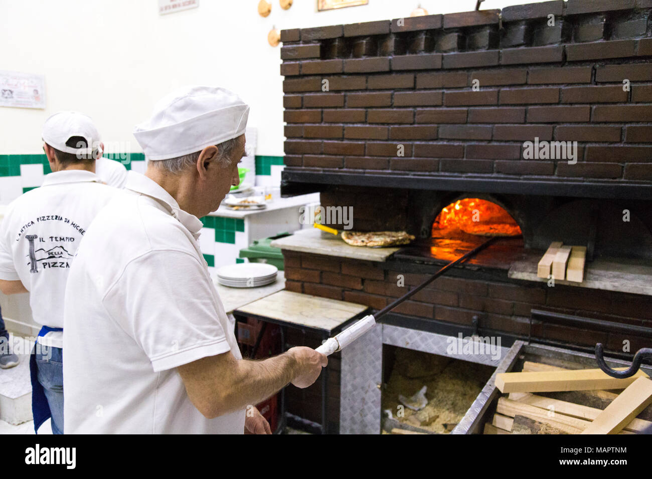 Uomo di cucina italiana tradizionale pizza nel forno a legna presso ... Uomo di cucina italiana tradizionale pizza nel forno a legna presso ...