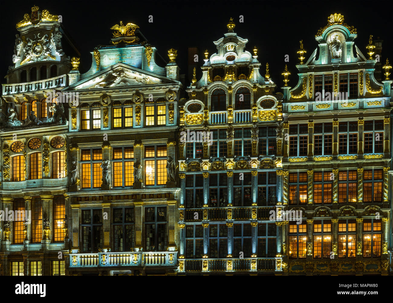 Facciate delle case delle corporazioni della Grand Place o la piazza principale di Bruxelles illuminata di notte in stile barocco italiano con influenze fiamminga, Belgio. Foto Stock