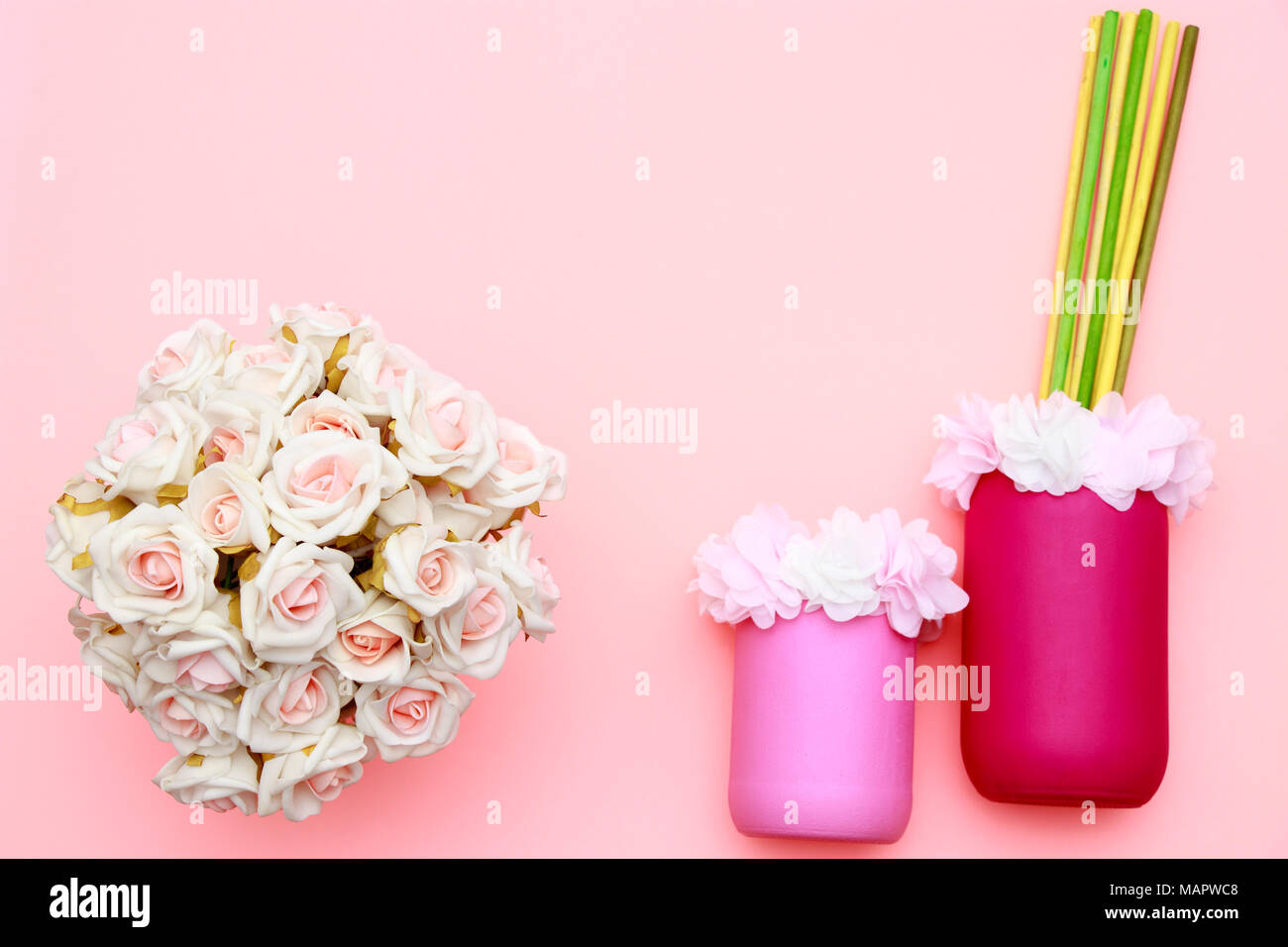 Bouquet di rose e fiori in vasi con sfondo rosa, madri day celebrazione, laici flat top visualizza lo spazio di copia Foto Stock
