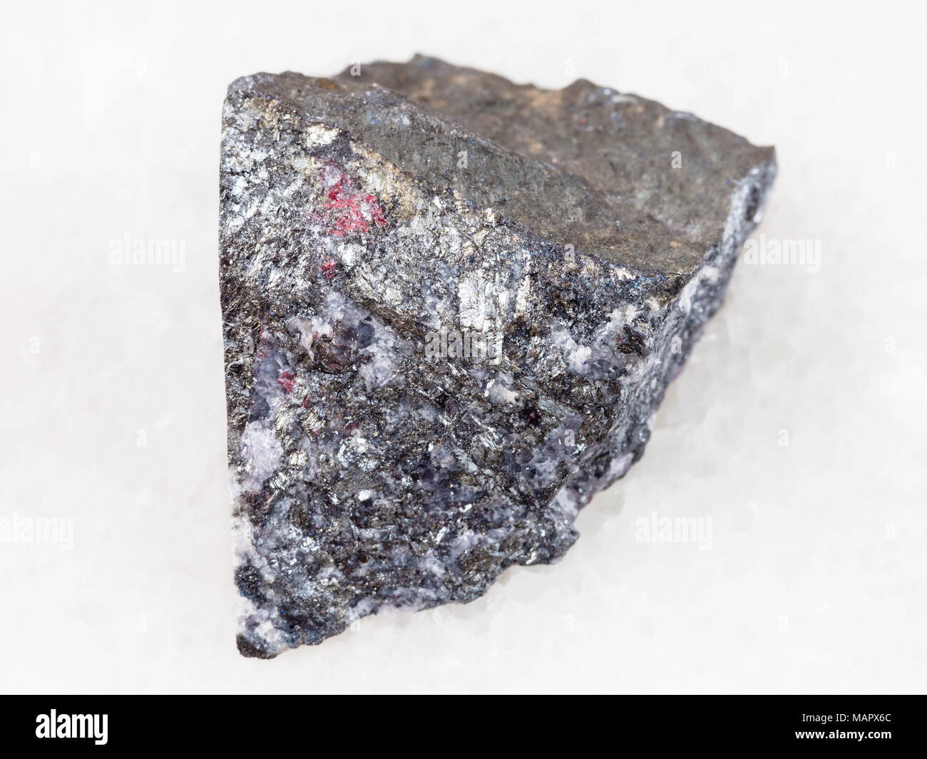 Le riprese in modalità macro di minerale naturale campione di roccia - antimonite ruvida sulla pietra di marmo bianco lo sfondo da Chauvay distretto del Kirghizistan Foto Stock