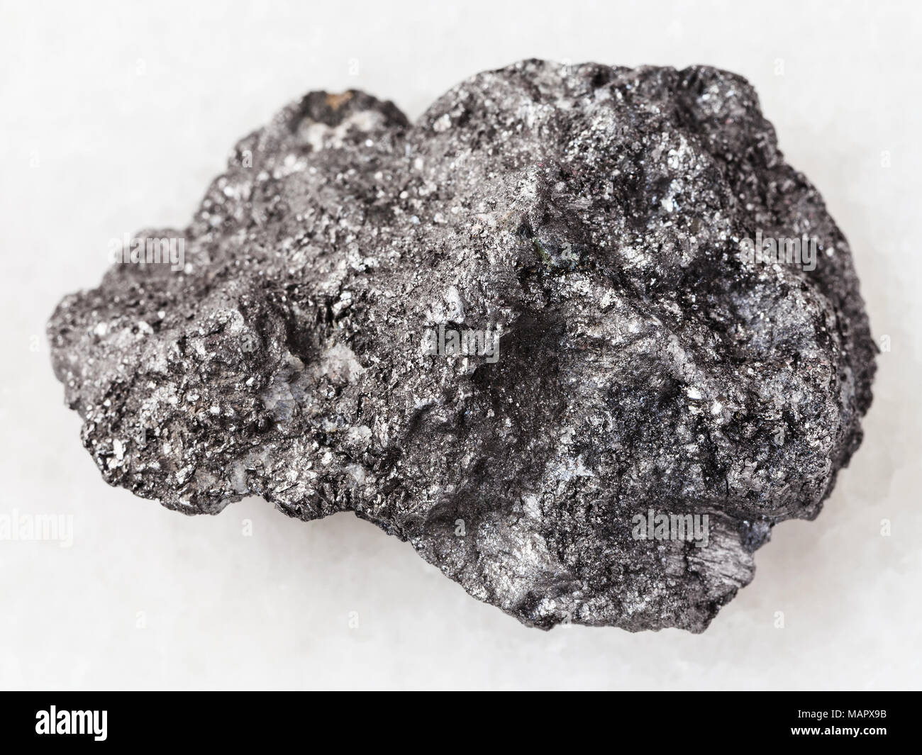 Le riprese in modalità macro di minerale naturale campione di roccia - materia prima pietra di grafite su marmo bianco lo sfondo da Bogotol regione orientale di Sayan montagne, Russia Foto Stock