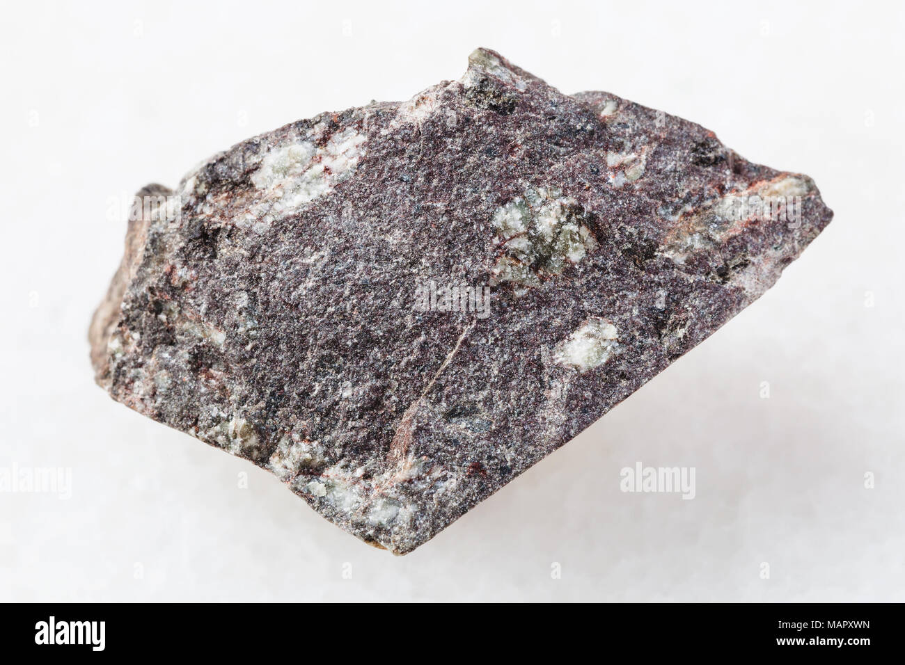 Le riprese in modalità macro di minerale naturale campione di roccia - materie porphyritic in pietra basaltica su marmo bianco sullo sfondo Foto Stock