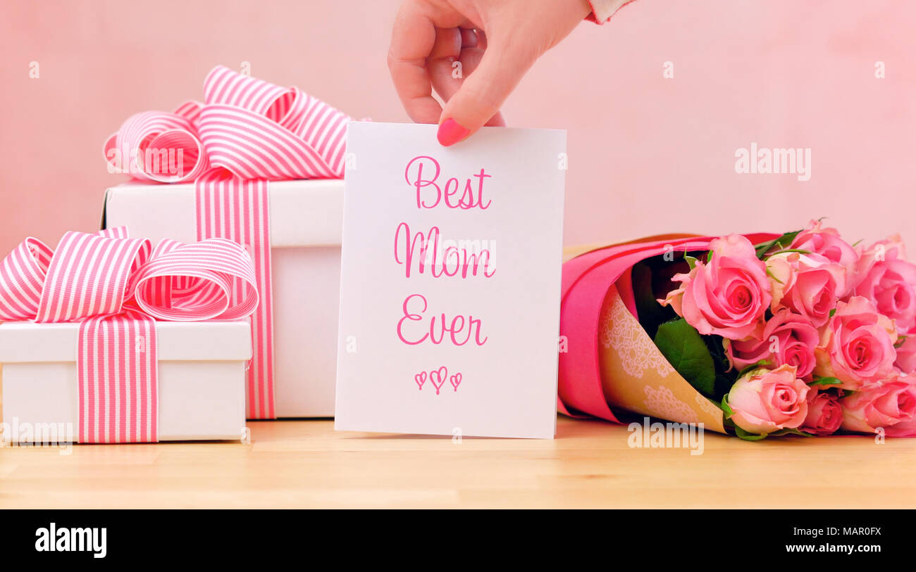 Felice la Festa della mamma regalo, le rose rosa e migliori mai Mom bigliettino sul tavolo. Foto Stock