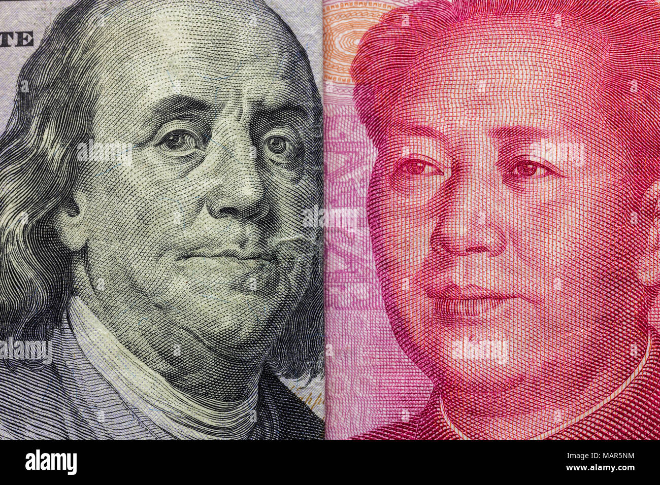 Close up di un centinaio di dollaro e 100 Yaun banconote con focus su ritratti di Benjamin Franklin e di Mao Tse-tung/USA vs Cina guerra commerciale nozione Foto Stock