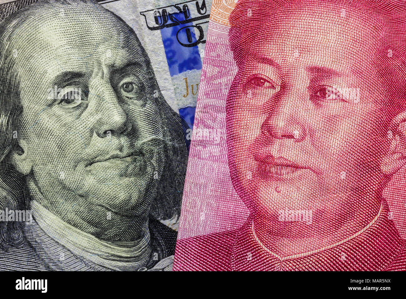 Close up di un centinaio di dollaro e 100 Yaun banconote con focus su ritratti di Benjamin Franklin e di Mao Tse-tung/USA vs Cina guerra commerciale nozione Foto Stock