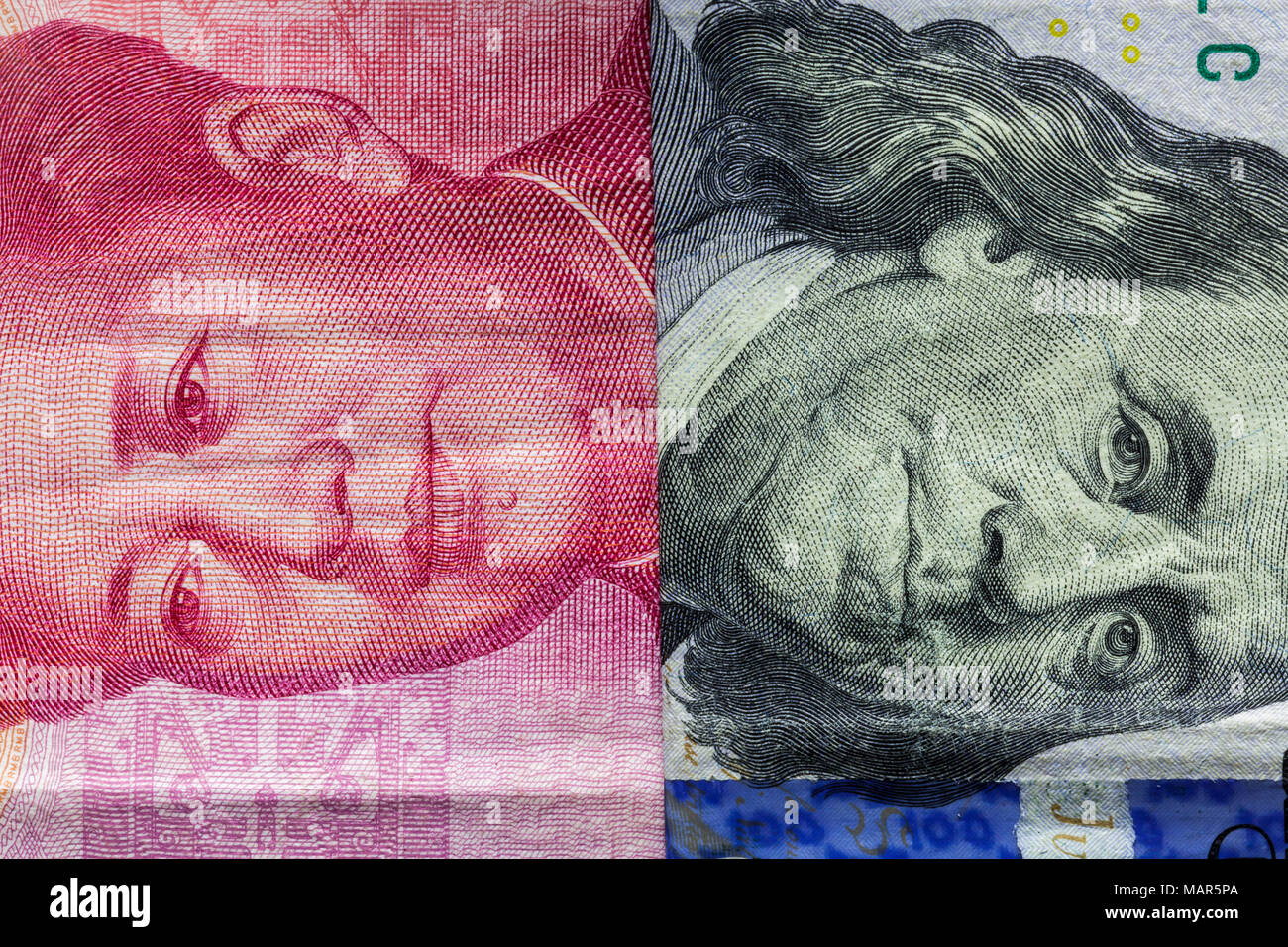 Close up di un centinaio di dollaro e 100 Yaun banconote con focus su ritratti di Benjamin Franklin e di Mao Tse-tung/USA vs Cina guerra commerciale nozione Foto Stock