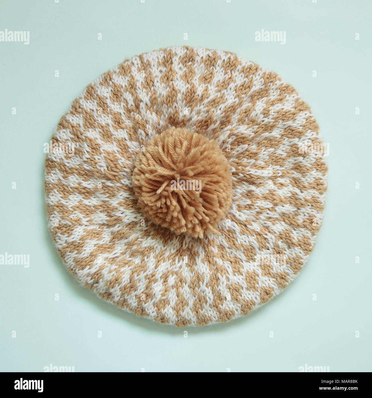 Cappellino con pompon isolato su sfondo verde chiaro Foto Stock