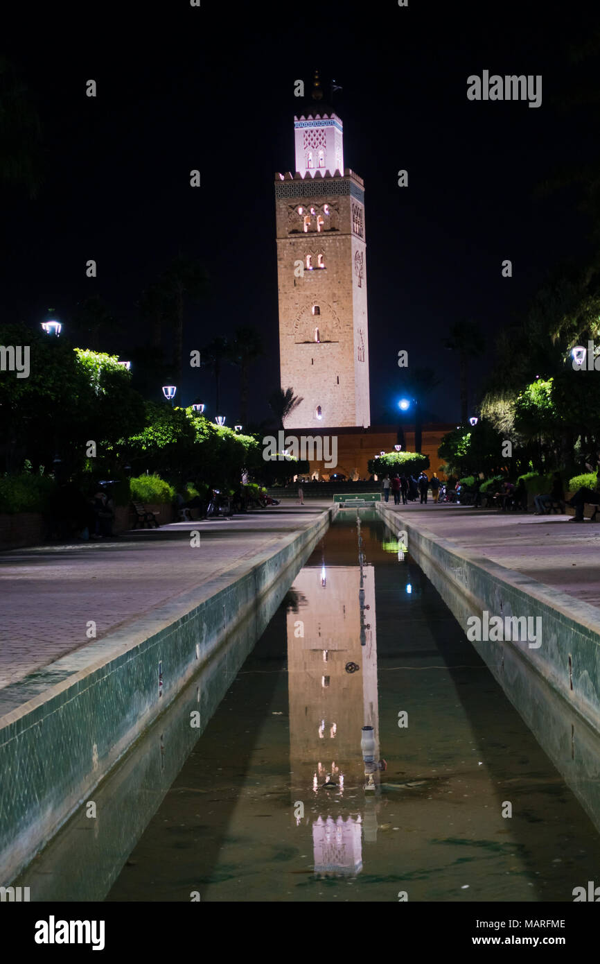 La riflessione in una fontana acqua della moschea di Koutoubia di notte a Marrakech, Marocco Foto Stock