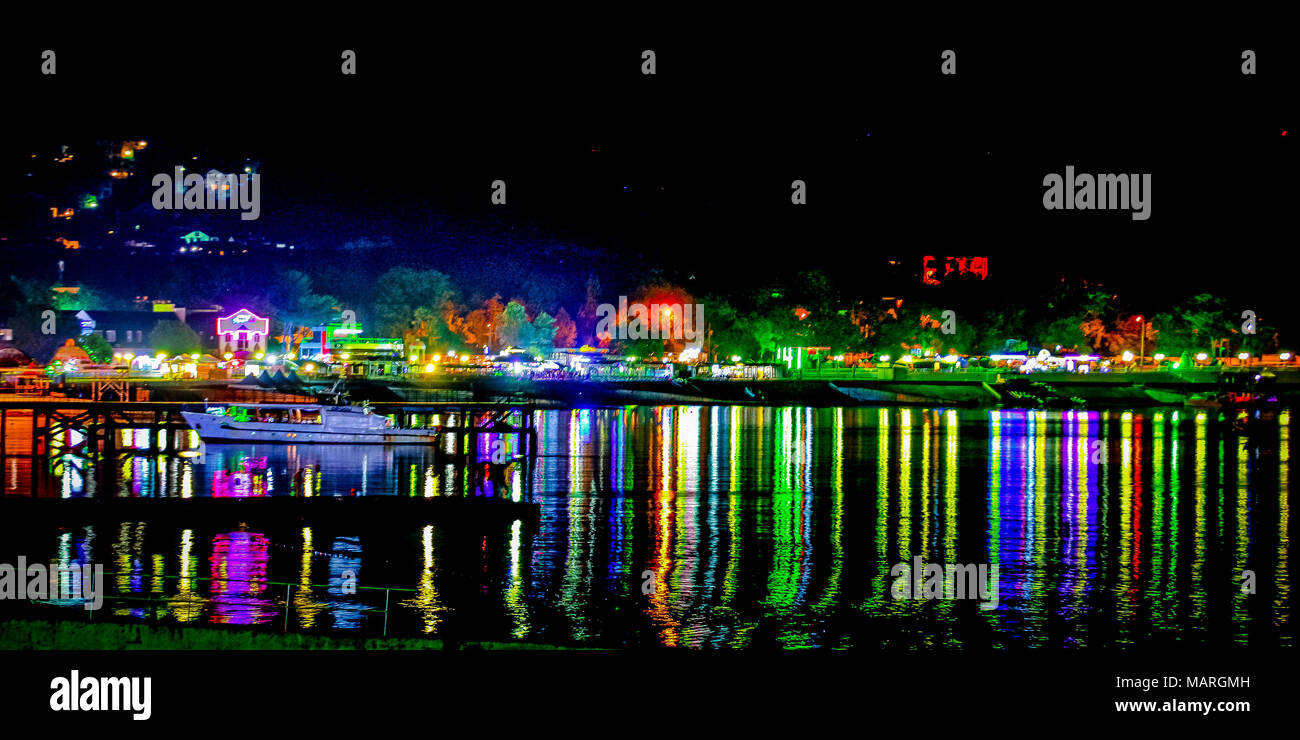 Paesaggio notturno dal mare. Colorate luci luminose sono riflessi nell'acqua. Foto Stock