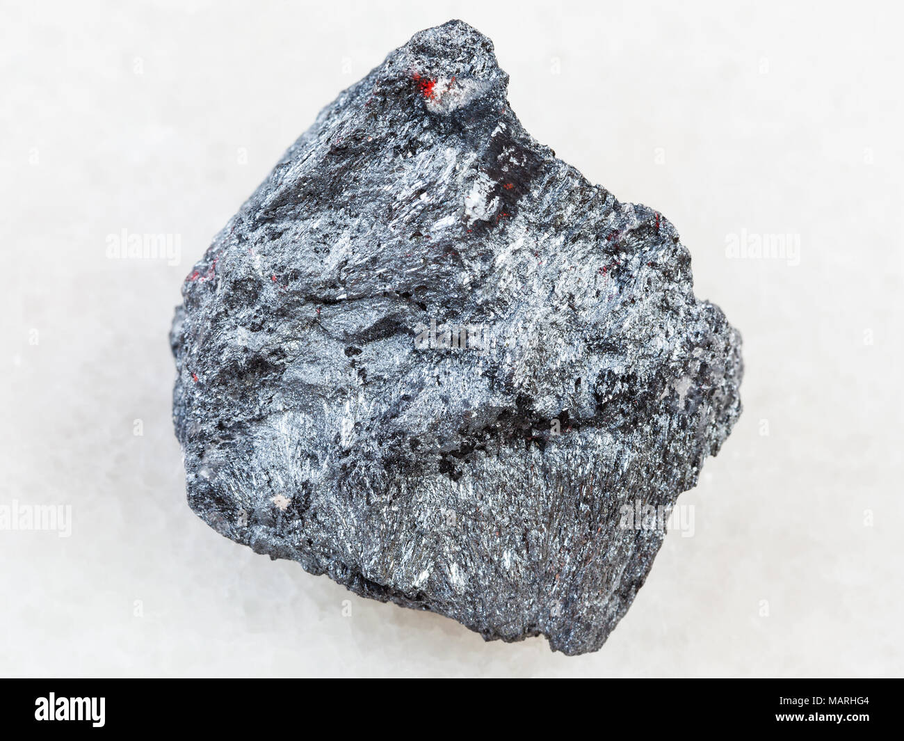 Le riprese in modalità macro di minerale naturale campione di roccia - Materie minerali di antimonio (Stibnite) pietra su marmo bianco sfondo dall'Ucraina Foto Stock