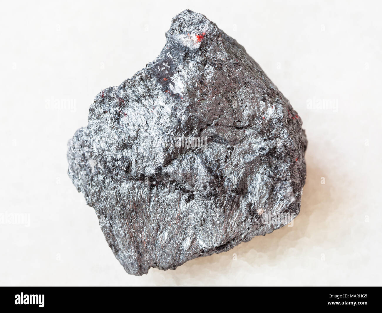 Le riprese in modalità macro di minerale naturale campione di roccia - ruvido minerale di antimonio (Stibnite) pietra su marmo bianco sfondo dall'Ucraina Foto Stock