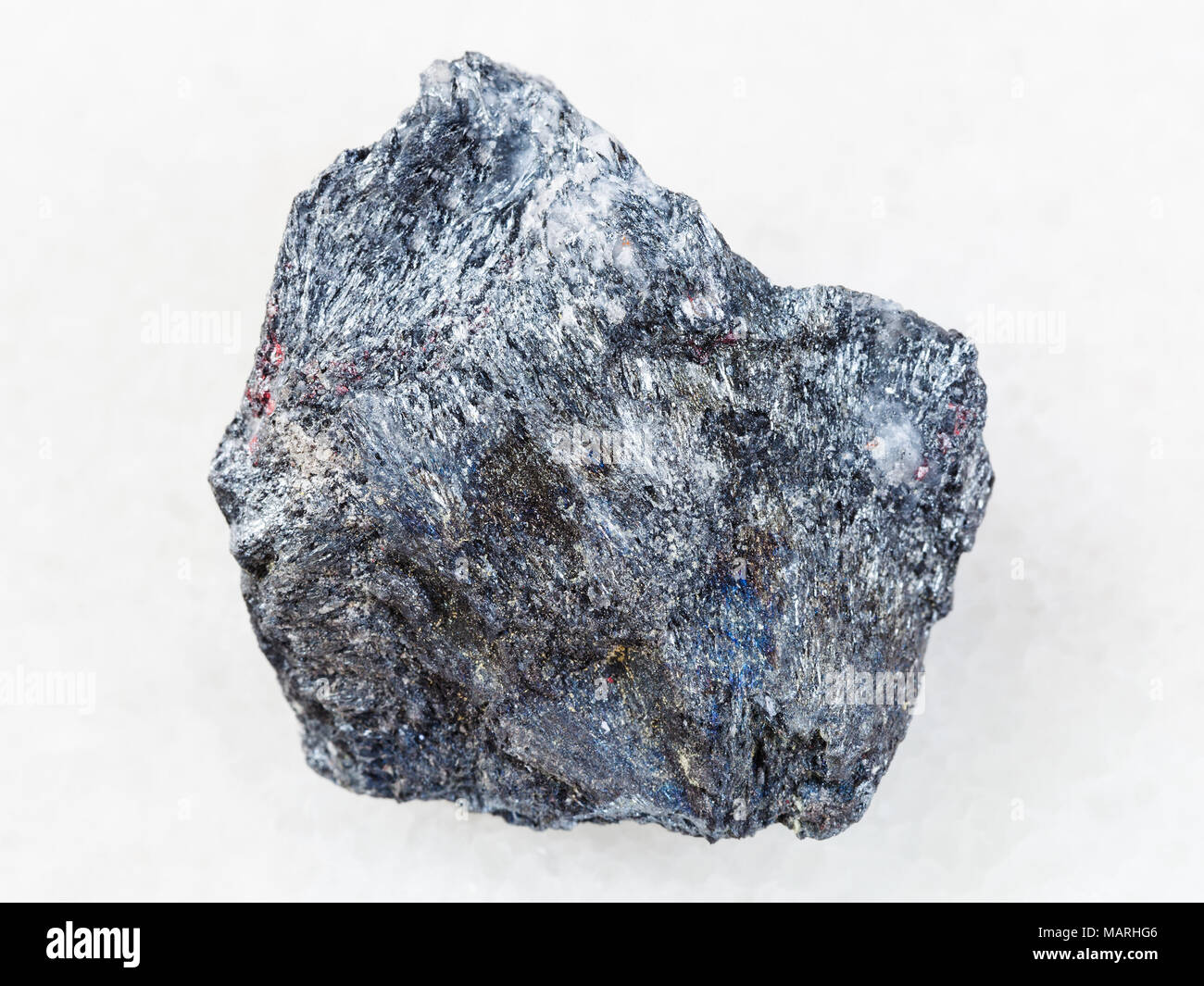 Le riprese in modalità macro di minerale naturale campione di roccia - Il minerale di antimonio (Stibnite) pietra su marmo bianco sfondo dall'Ucraina Foto Stock