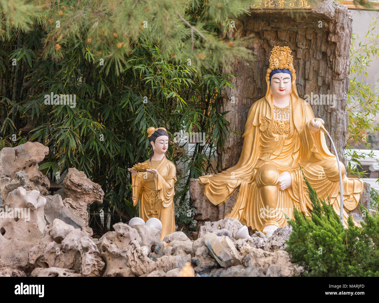 Hacienda Heights, CA, Stati Uniti d'America - 23 Marzo 2018: primo piano della golden Avalokitesvara, Guanyin, in giardino con quattro re celeste a Hsi Lai tempio buddista. Foto Stock