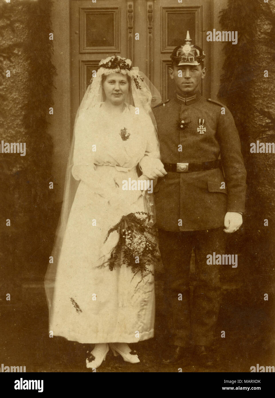 Speciale sposi: giovane donna in bianco e il soldato con casco spiked, Foto Stock