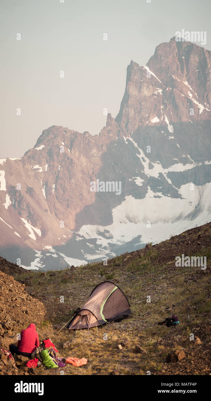 Piccola tenda e un alpine/montagna campeggio nelle montagne costiere della Columbia Britannica (Canada). Magestic picco di montagna in background. Foto Stock
