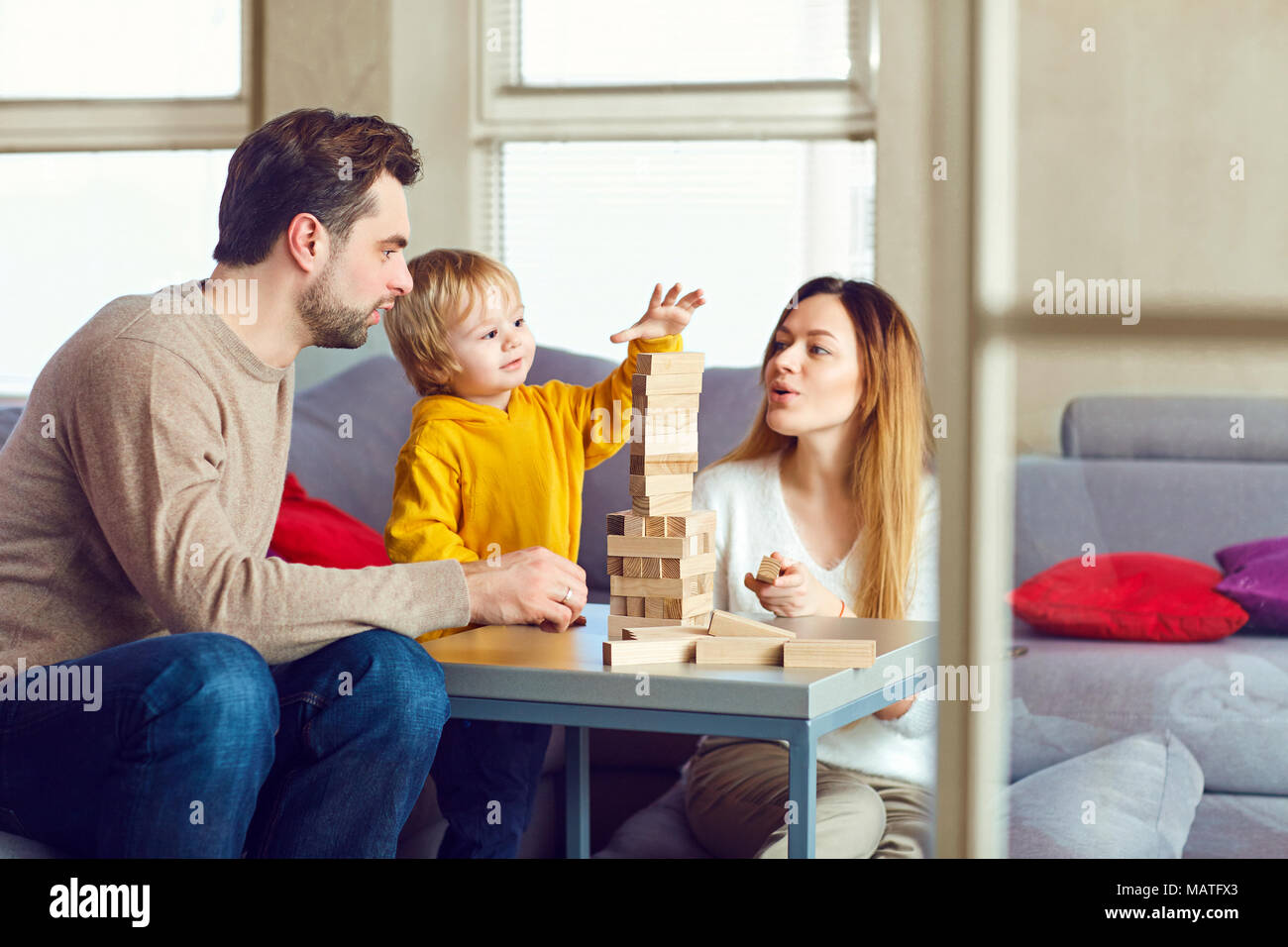 Un bambino con genitori gioca giochi da tavolo sul tavolo. Foto Stock