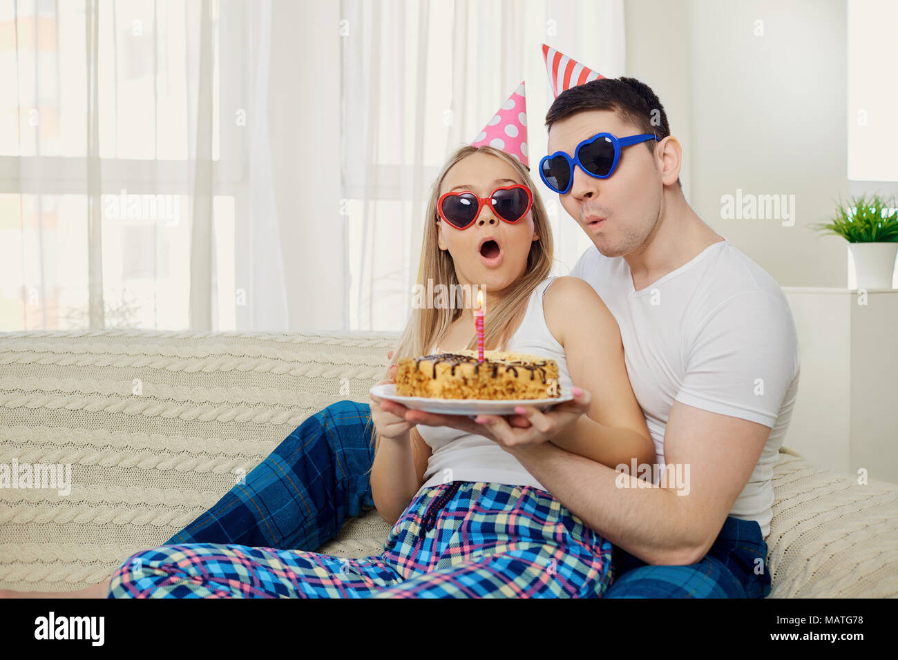 Giovane con una torta con le candele si congratula con il giorno del suo compleanno su Foto Stock