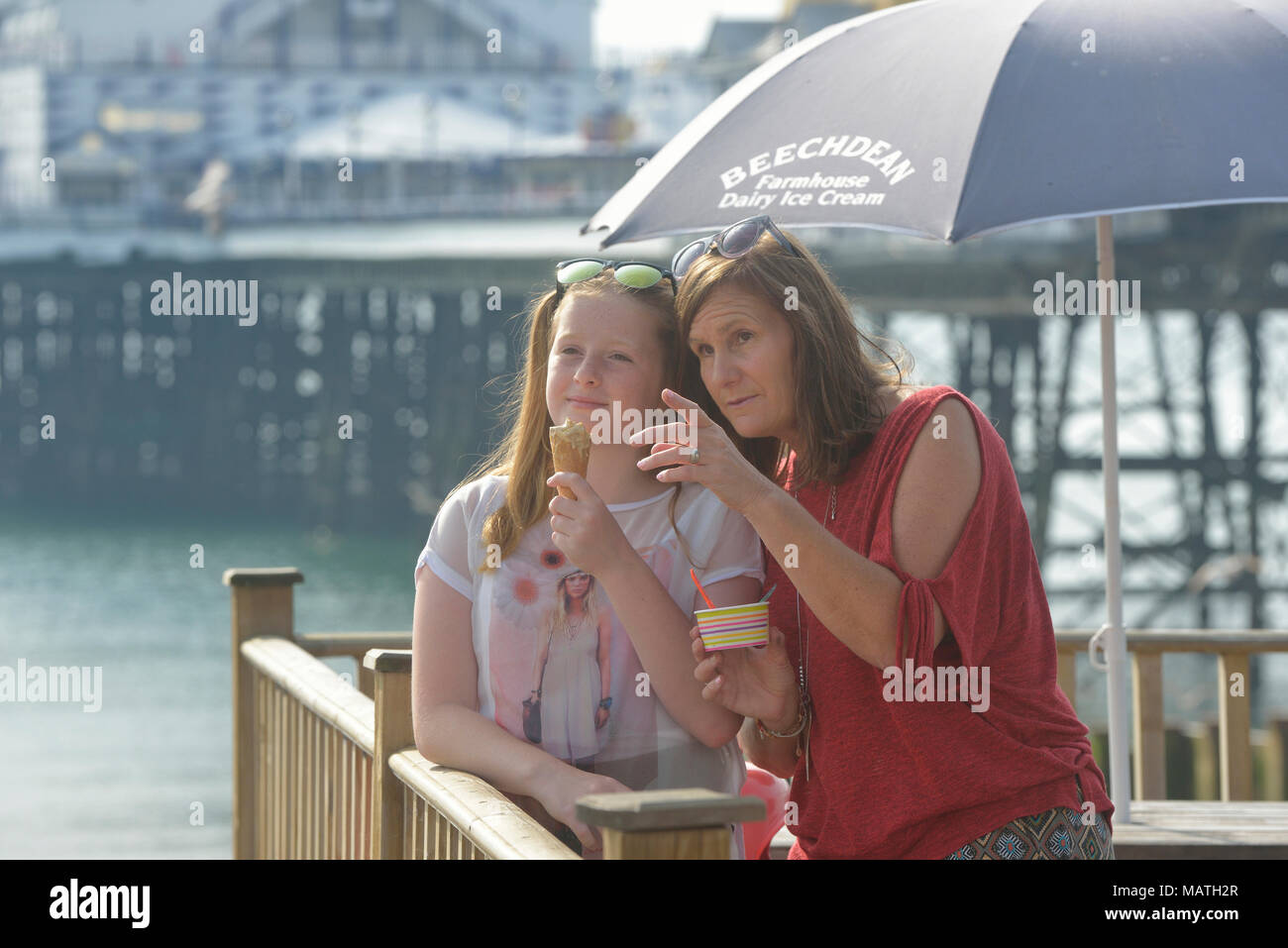 Madre e figlia a mangiare il gelato, Eastbourne, East Sussex, England, Regno Unito Foto Stock