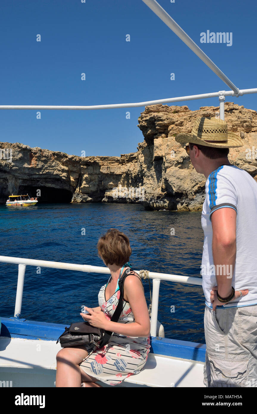 Giovane adulto giovane su un viaggio in barca visitando le grotte di Comino. Isola di Comino e Malta Foto Stock