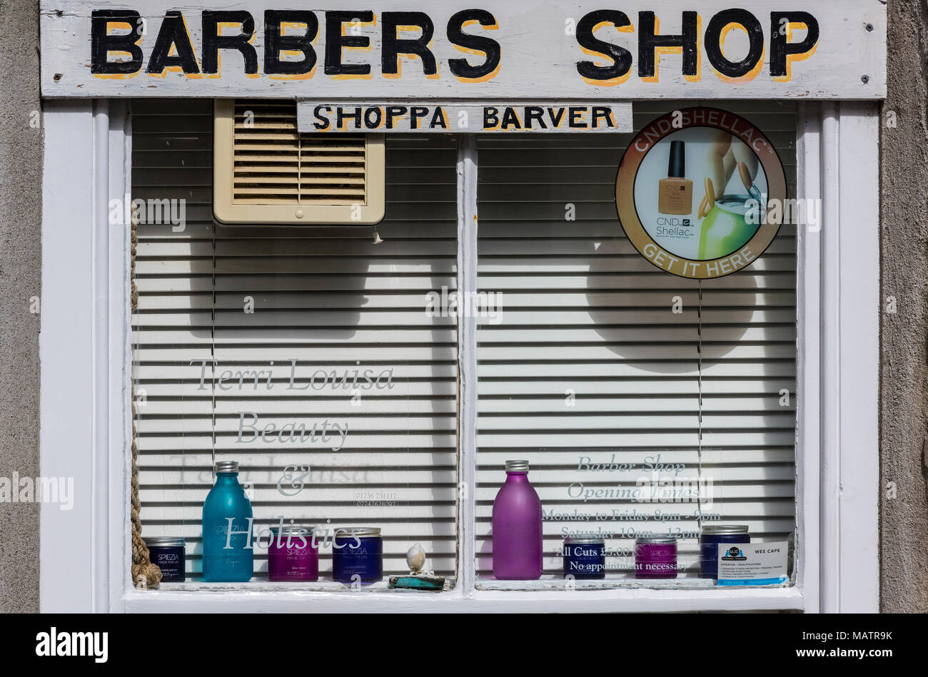 La vetrina di un negozio di barbiere in un edificio tradizionale in st Ives in Cornovaglia occidentale. il taglio di capelli e saloni con pubblicità in dialetto locale Cornovaglia Foto Stock