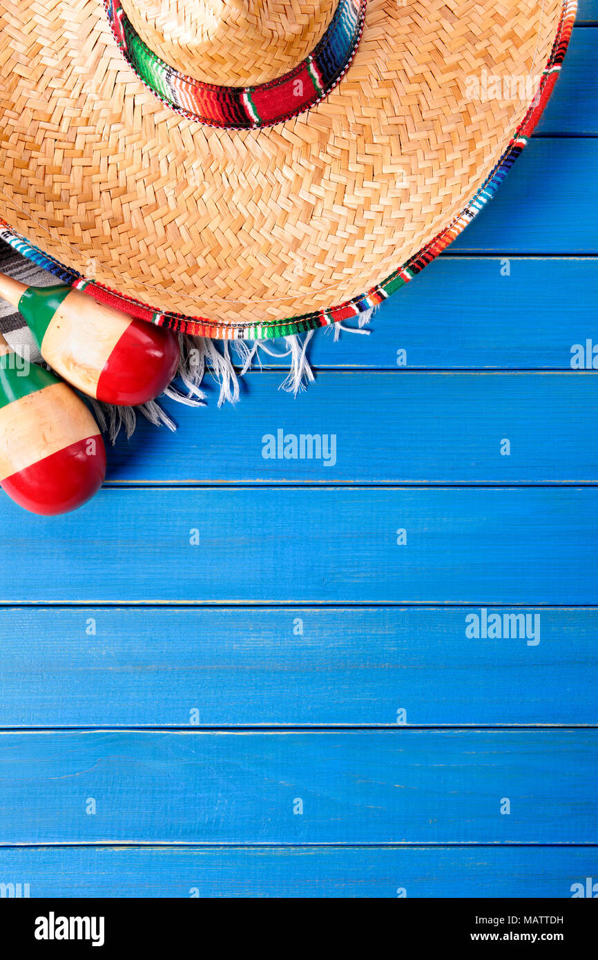 Sombrero messicano e maracas con tradizionale serape coperta prevista su un vecchio blu dipinta in legno di pino piano. Spazio per la copia. Foto Stock