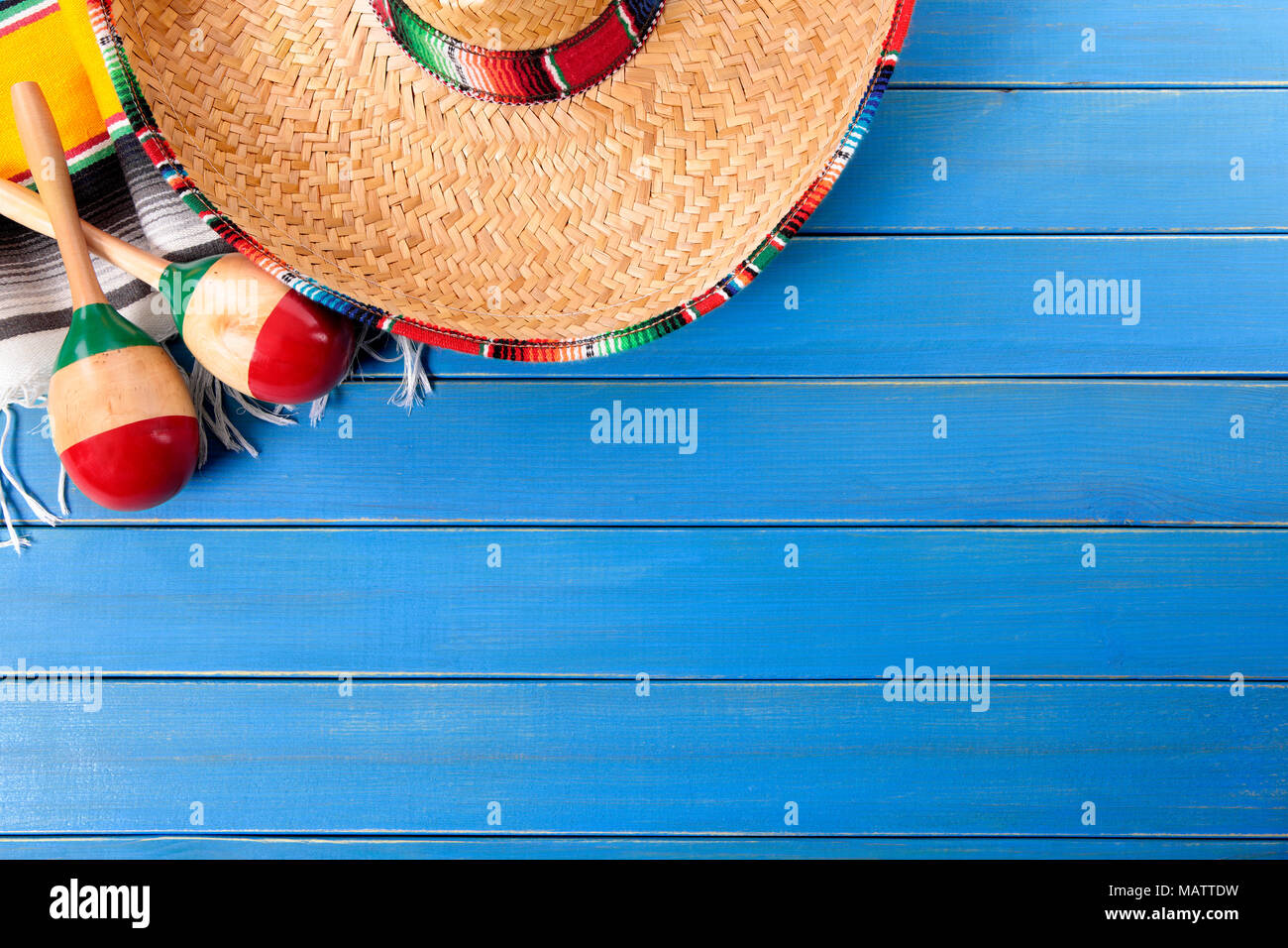 Sombrero messicano e maracas con tradizionale serape coperta prevista su un vecchio blu dipinta in legno di pino piano. Spazio per la copia. Foto Stock