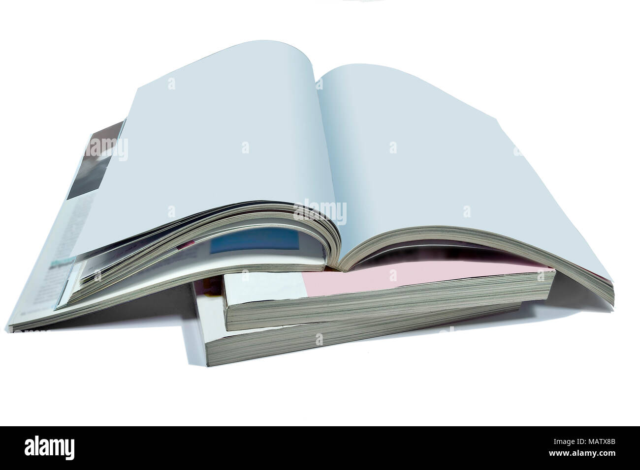 Aperto le pagine bianche di rivista o libro, catalogo sulla pila di riviste spesso isolate su uno sfondo bianco - Un mock up per dimostrare il tuo design Foto Stock