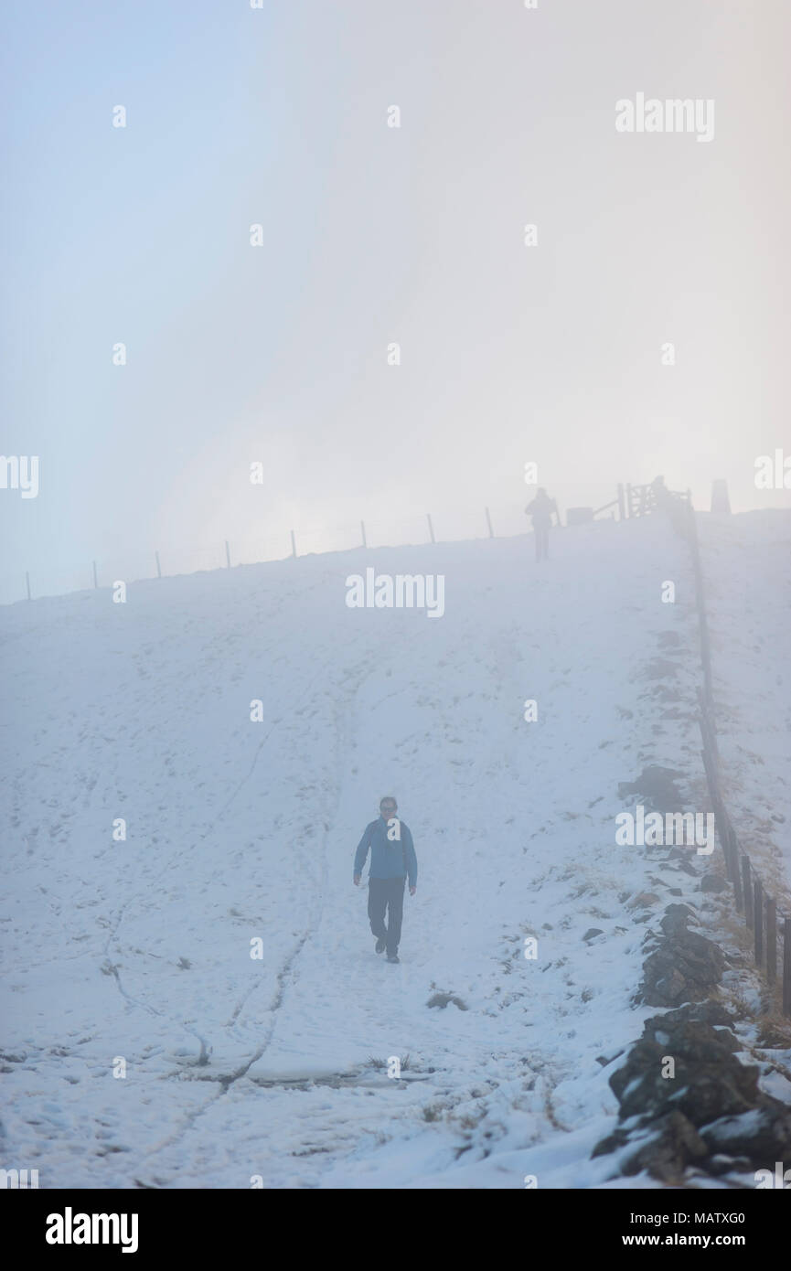 La gente camminare lungo una coperta di neve nel percorso di Pentland Hills nei pressi di Edimburgo Foto Stock