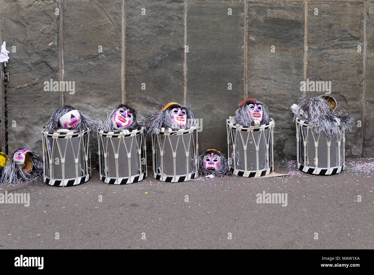 Il Carnevale di Basilea. Spiegelgasse, Basilea, Svizzera - Febbraio 21st, 2018. Linea di rullanti e maschere di fronte a un muro grigio Foto Stock