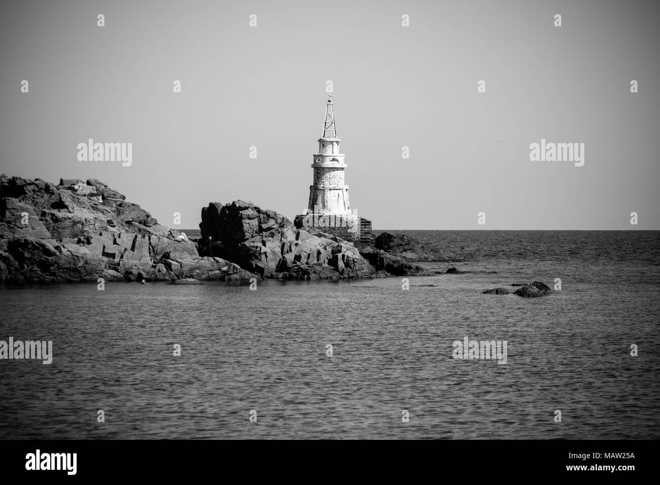 Un faro sulle rocce. Mar Nero. Ahtopol. La Bulgaria. In bianco e nero. Foto Stock