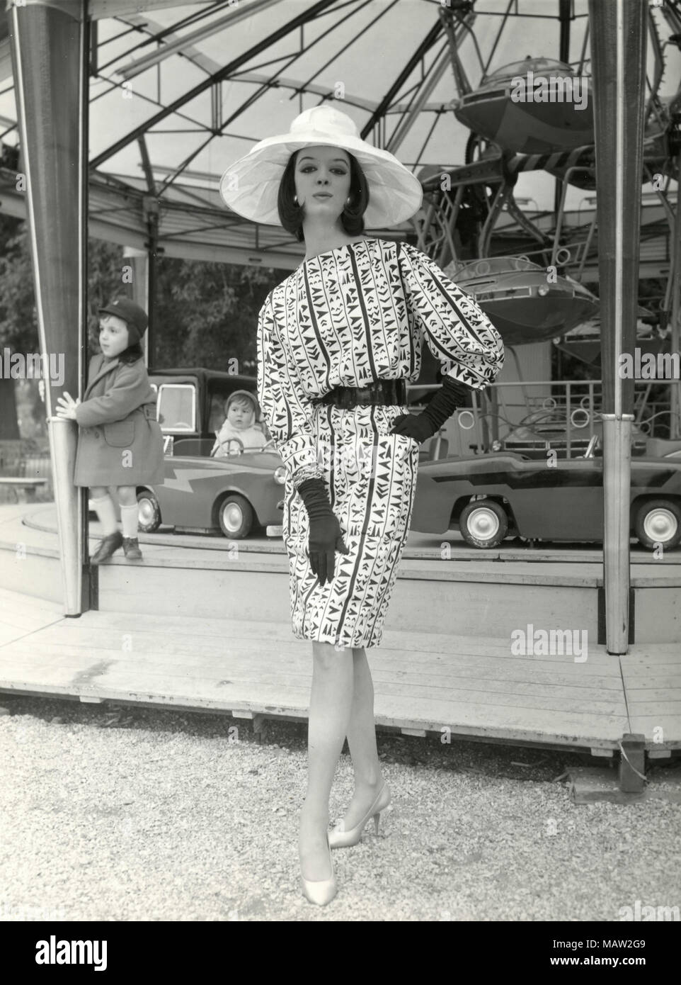 Modello dagli anni sessanta indossando grande cappello, guanti lunghi, e modellato abito, Italia Foto Stock