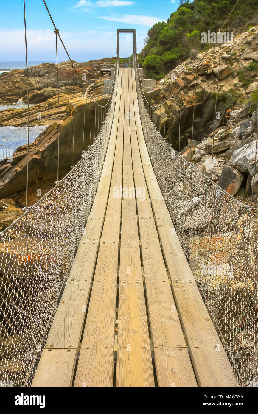 Vista prospettica della sospensione ponte sul fiume tempeste di bocca in Tsitsikamma National Park, Eastern Cape, vicino a Plettenberg Bay in Sud Africa. Una popolare destinazione turistica lungo la Garden Route. Foto Stock