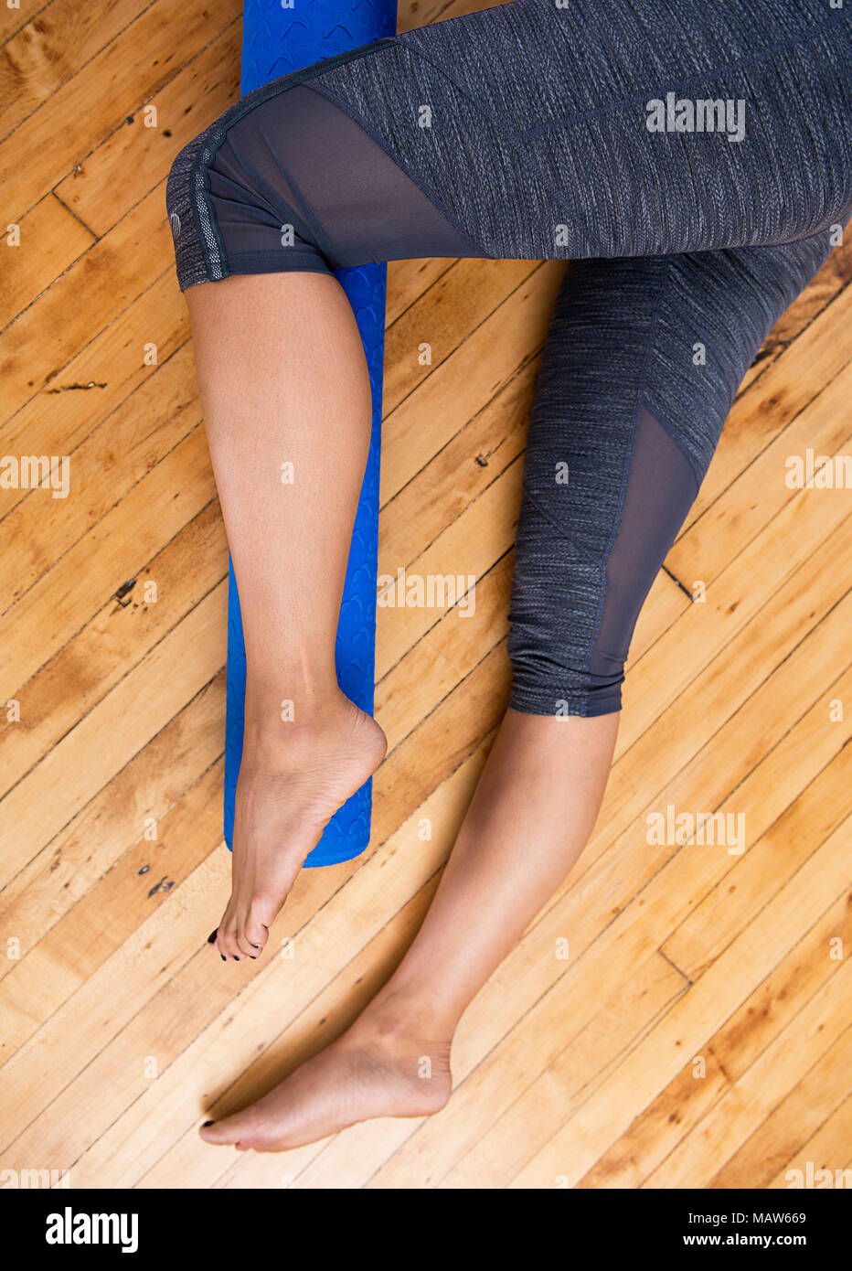 Una donna rotolare fuori la sua gamba con un rullo di schiuma Foto Stock