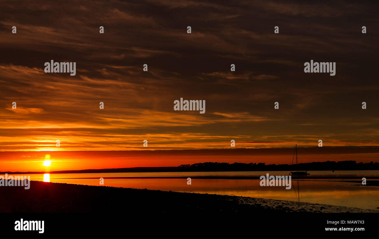Yacht ormeggiati sul Menai Straits al tramonto, costa del Galles Settentrionale Foto Stock